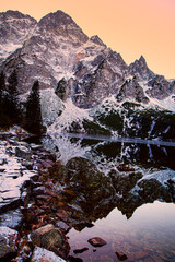 Beautiful sunset or sunrise in the mountains, covered with snow. High mountain reflects on the...