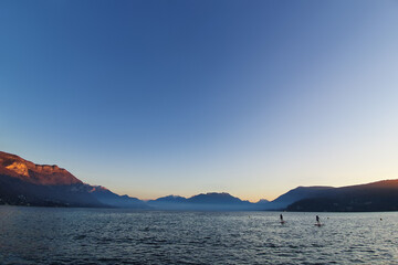 Two paddlers in Annecy lake at sunset
