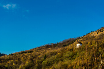 White chapel on a hill, autumn landscape