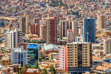 Nuestra Senora de La Paz rapidly growing colorful city  with modern buildings and lots of living houses scattered on the hill in background, Bolivia.