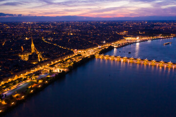 Fototapeta premium Panoramic aerial view of illuminated Bordeaux city on Garonne river at night