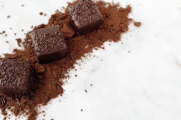 Dark Chocolate Petit Four Cakes on Cocoa and Sprinkles with Negative Space Valentine's Day Dessert