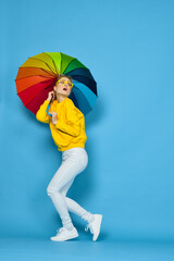 woman with multicolored umbrella in yellow sweater posing rainbow colors