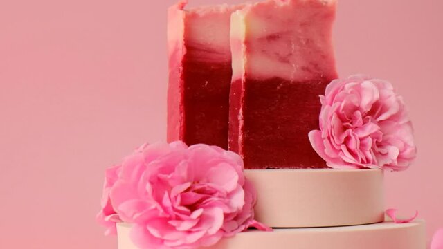 Pink soap bars and pink roses on pink background.Rose soap. Organic Rose Soap with Rose extract. 4k footage
