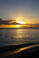 SUNSET ON THE BEACH WITH ORANGE LIGHT AND BLUE SKY WITH SOME CLOUDS