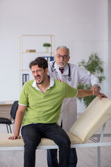 Fototapeta premium Young male patient visiting old male doctor