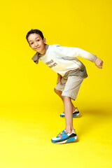 Funny mixed race kid boy posing on bright yellow background