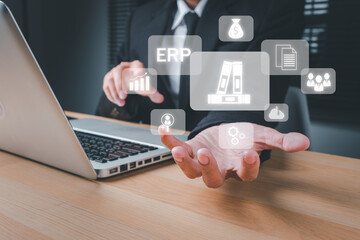 Fototapeta premium ERP, document management concept, Businessman working with laptop computer and hand holding business icon on virtual screen, Software for archiving, Business processes