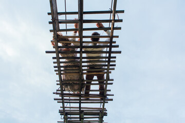 Beautiful young couple laying on the suspension bridge