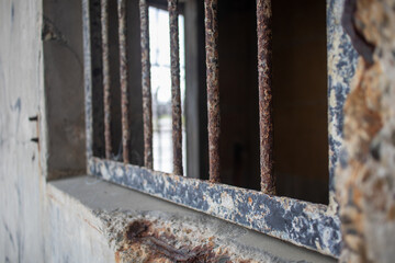 Spooky abandoned World War 2 building with rusty iron bars for windows with a deliberately blurred background due to shallow depth of field  