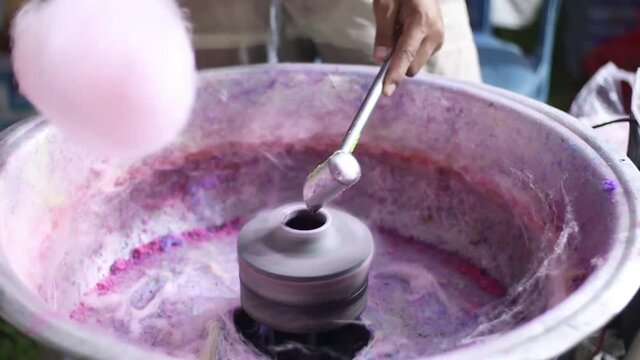 Full HD video of the process of making cotton candy, with the main ingredients of sugar and pink food coloring, candy floss machine