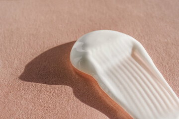 The texture of the white cream on a pink background.