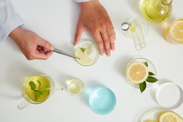 White Background with a doctor for Biological experiment presentation lemon extract and yellow water in biological test tubes. Production of cosmetics based on lemon , top view