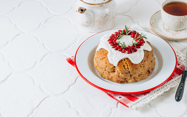 Traditional Christmas fruit pudding on white festive background.