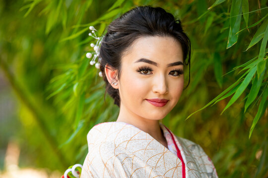 Portrait of smiling woman wearing kimono standing in park
