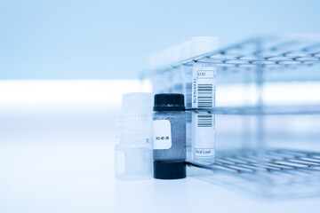 Sample specimen in test tube and chemistry and immunology reagent bottle on white table background...