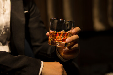 Closeup businessmen holding a glass of whiskey