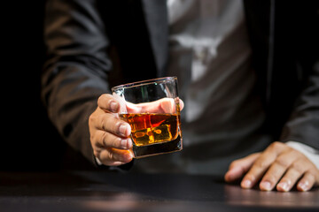 Closeup businessmen holding a glass of whiskey