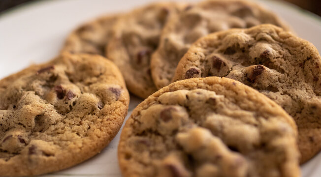Close up of Golden brown chocolate chip cookies on plate with out of focus background and foreground