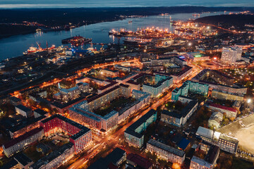 Obraz premium Evening northern city, port, bay, Murmansk, North sea, city lights, shooting from a height, from a drone, from a quadcopter
