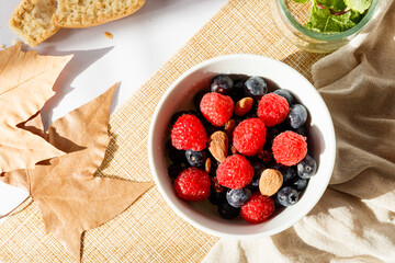 Autumn style breakfast with red fruits, nuts, honey, milk and toast