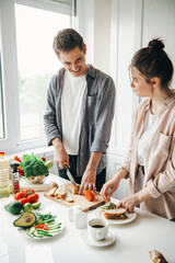 Man and woman are having fun together in the kitchen while making breakfast. Healthy meal. Family cooking. Healthy diet.