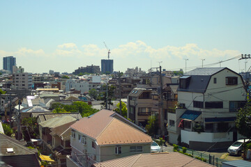Aerial view of building and house of suburban area in Japan with clouds in blue sunny sky background. No people.
