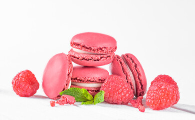 Tasty Colorful Macarons with Raspberries on White Background