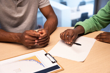 Close up of african american people signing contract in the office.