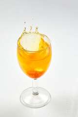 A dice falling into a glass of orange liquid caused a splash