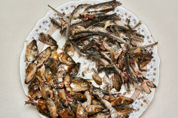 Fish heads and bones left after eating on a plate.