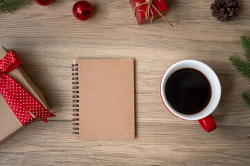 Blank notebook, black coffee cup and Christmas gift on wood table, Top view and copy space. Xmas, Happy New Year, Goals, Resolution, To do list, Strategy and Plan concept
