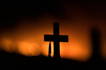 Silhouette of a cross in a cemetary during a wildfire