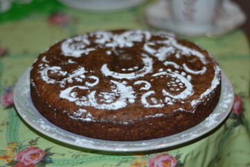 Homemade cake sprinkled with powdered sugar.