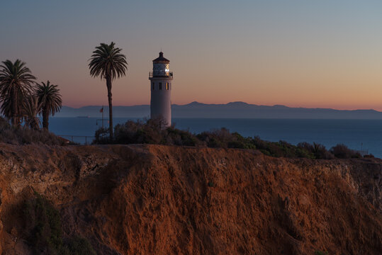 This image shows the Point Vicente Lighthouse in Rancho Palos Verdes at dusk. The Santa Catalina Island is shown in the background.