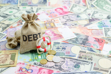 Credit default insurance debt security concept : Debt bags, red lifebuoy on world banknotes e.g dollar, yuan, depicts a financial agreement that mitigates the risk of loss from default by a borrower - obrazy, fototapety, plakaty