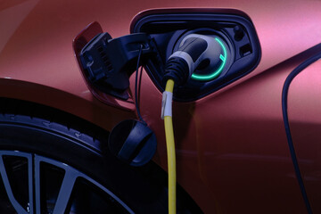 Close-up hand grip plug of industrial electric charging machine connected with socket charge on...