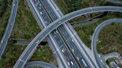 Top down aerial view from drone on modern traffic junction of multiple lane highway road in...