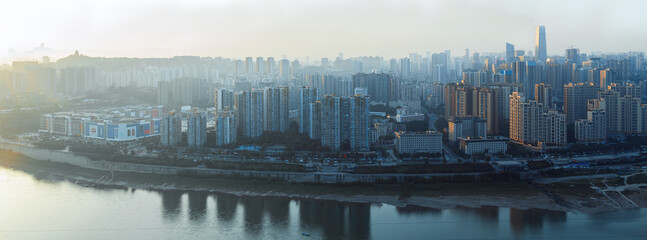 Naklejka premium The city is in Chongqing, China. The river is called the Jialing River. At sunset, the city has warm sunlight afterglow