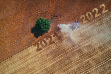 2022 Happy new year concept of aerial view on the combine working on the large wheat field