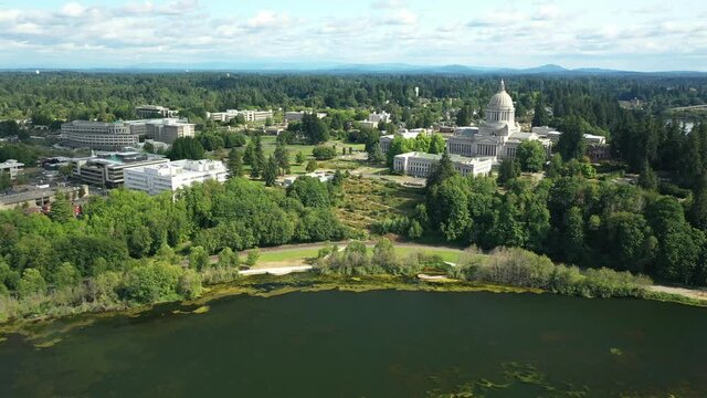 Cinematic 4K aerial drone dolly in shot of the Washington State Capitol Building and Campus, Capitol Lake, with a panoramic view of Historic District in Olympia, Washington
