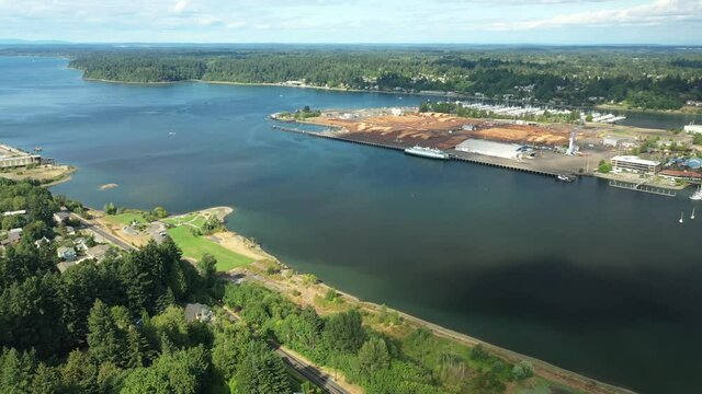 Cinematic 4K aerial drone pan shot of West Bay, Crestline, Westside Olympia with a panoramic view of the Entrance Channel, harbor with port and downtown in Olympia, Washington