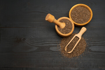 Organic natural chia seeds, bowl and wooden scoop close-up on wooden background or table