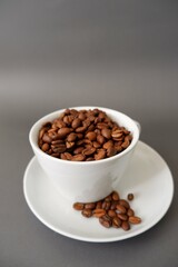 Coffee beans and cup & saucer on gray background. Cafe, Coffee, restaurant design elements.