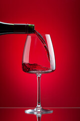 Red wine pouring from bottle into glass