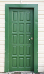 the usual traditional entrance door made of green wood, finished with siding in the house