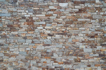 Old ancient stone wall background of medieval house brick horizontal stones wallpaper