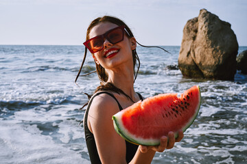 pretty woman in a black swimsuit with a watermelon in her hands summer Ocean