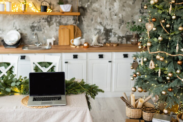 Laptop. Christmas tree and gifts on background