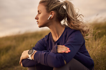Sportswoman listening to music in countryside